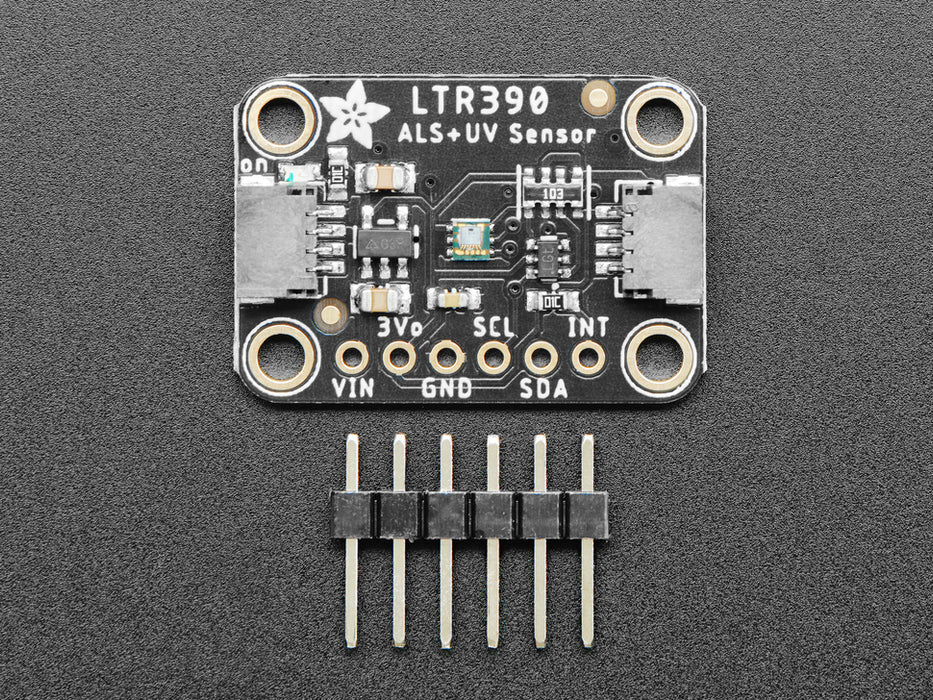 UV lamp swinging over onto sensor, connected to Feather. OLED display shows changing UV and light levels.