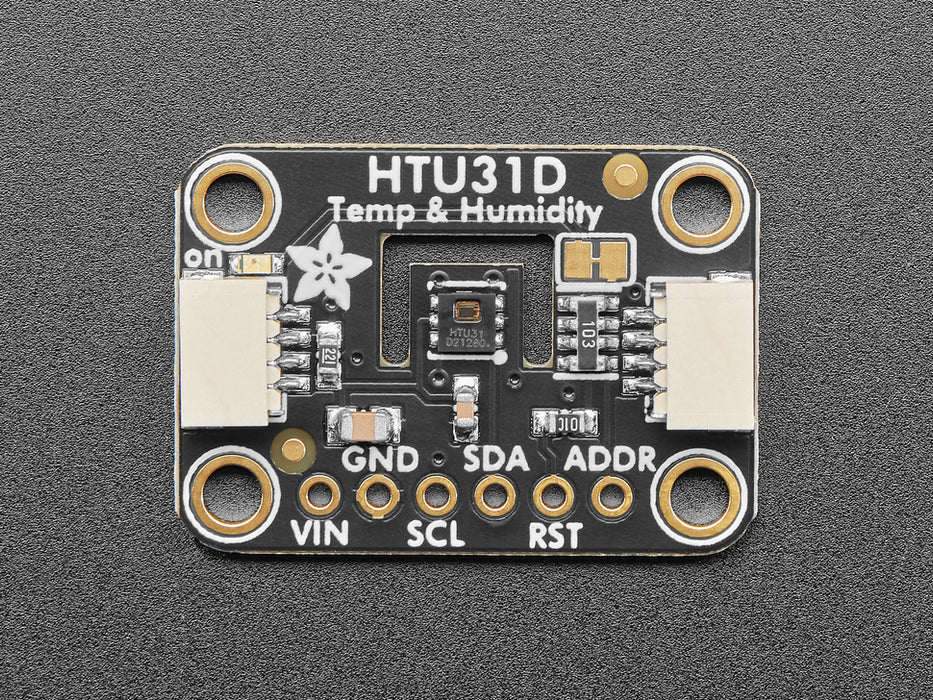 Top view of humidity breakout above an OLED display FeatherWing. The OLED display reads: "HTU31 Demo Temp: 24.19ºC Hum: 37.13%"