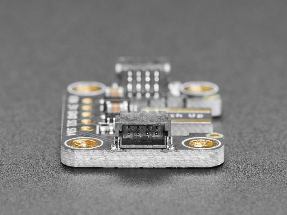 Hand holding a Wiichuck controller pressing buttons. The controller is connected to the breakout wired to a Feather with OLED showing the streaming controller data