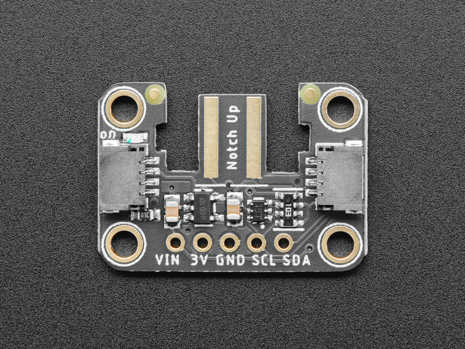 Hand holding a Wiichuck controller pressing buttons. The controller is connected to the breakout wired to a Feather with OLED showing the streaming controller data