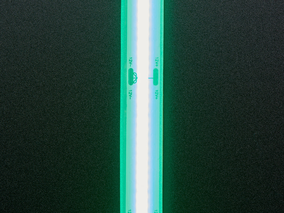 Two hands repeatedly bending and manipulating lit-up flexible green LED strip