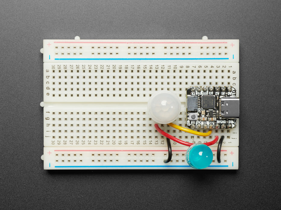 Topdown video of 3-pin PIR sensor assembled onto a breadboard. A hand passes over the sensor, and a blue LED to light up.