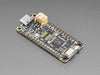 Angled shot of black rectangular microcontroller "Feather RP2040"