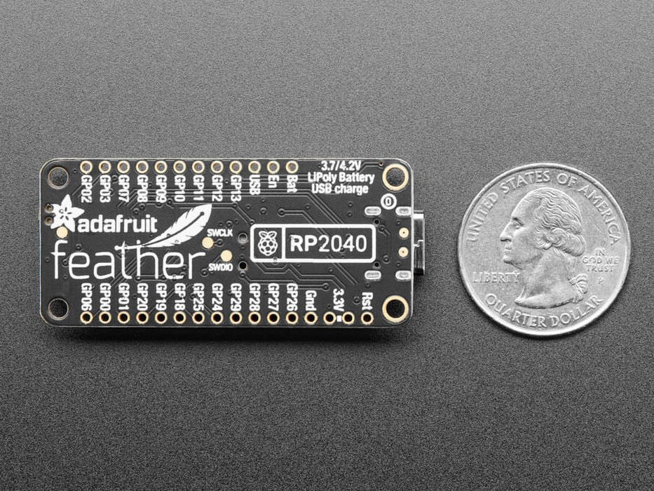 Angled shot of black rectangular microcontroller "Feather RP2040"