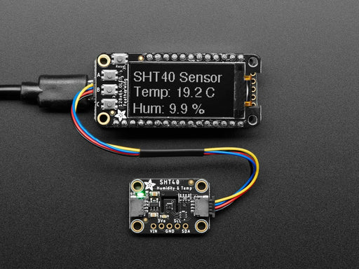 Adafruit Sensirion SHT40 Temperature & Humidity Sensor wired to Feather with QT cable, showing temperature and humidity on OLED.