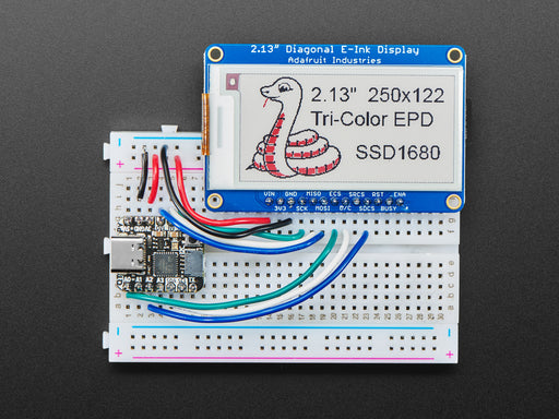 Video of a 2.13" tri-color eInk display assembled on a breadboard with jumper wires and a QT Py. Friendly snake in white-and-red, Blinka, appears on the display.