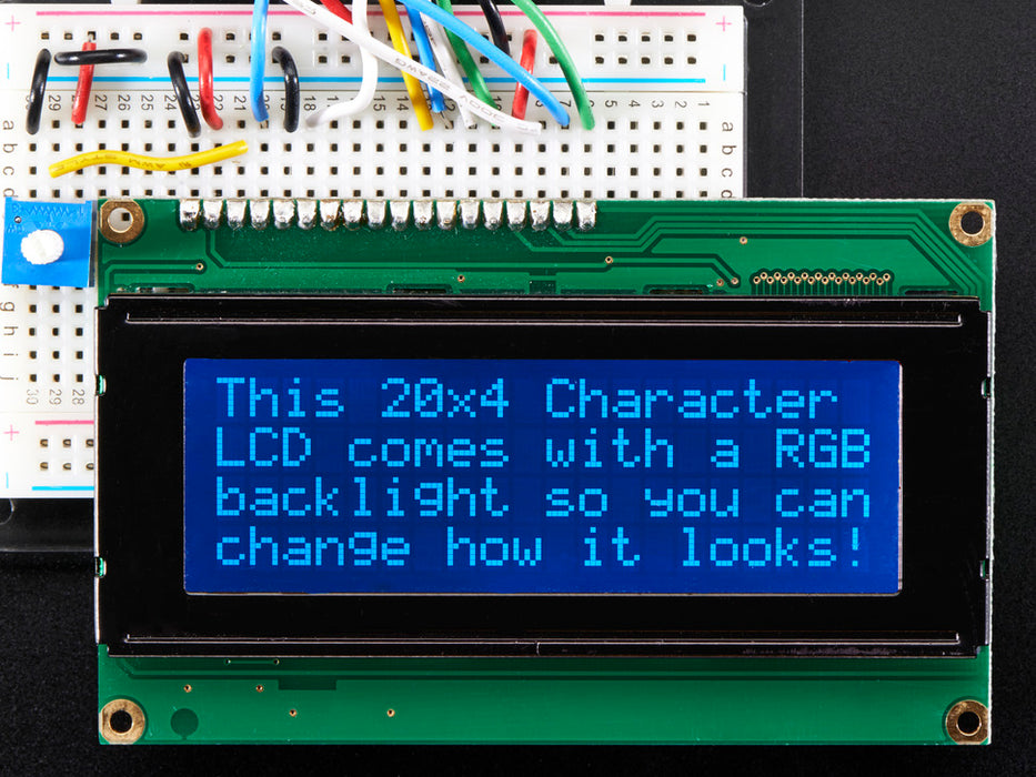 LCD wired on breadboard with backlight changing color with text displayed: "This 20x4 Character LCD comes with an RGB backlight so you can change how it looks".