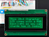 LCD wired on breadboard with backlight changing color with text displayed: "This 20x4 Character LCD comes with an RGB backlight so you can change how it looks".