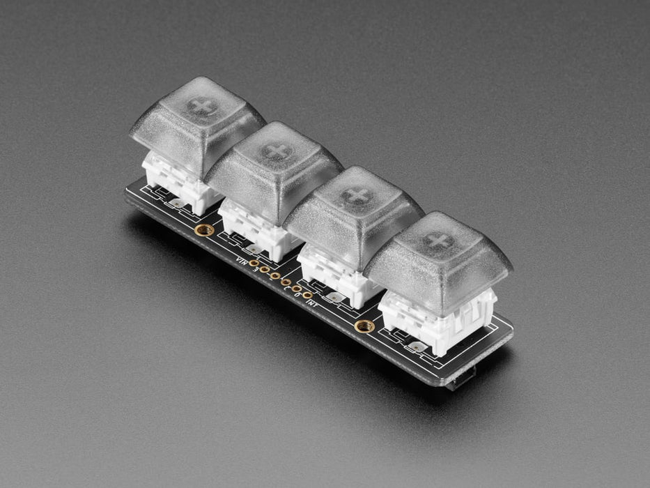 Top view video of a fully assembled NeoKey 1x4 QT I2C with switches and smoke gray keycaps powered by a QT Py on a breadboard. A hand reaches down to press the keys, which emit rainbow colors. 