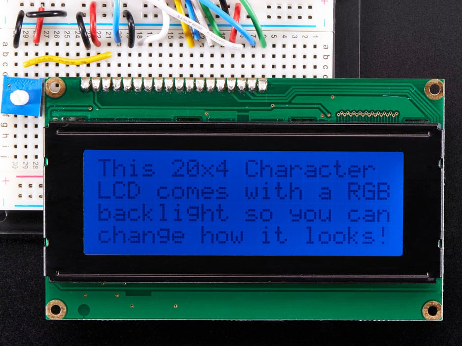 LCD wired on breadboard with backlight changing color with text displayed: "This 20x4 Character LCD comes with an RGB backlight so you can change how it looks".