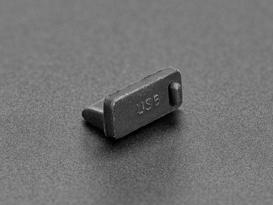 Close-up of a single black silicone USB A cover installed on a laptop's USB port.