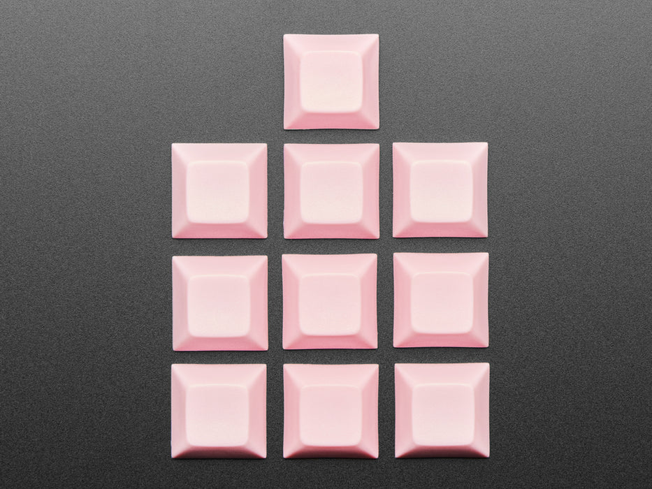 Angled shot of 10 pink plastic keycaps.