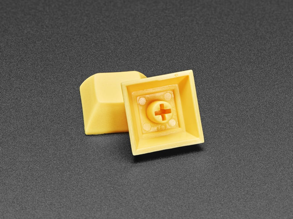 Angled shot of 10 dark yellow plastic keycaps.