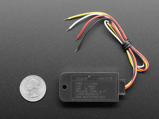 Top view of black humidity sensor sensor wired to a breadboard with an FeatherWing OLED display. The OLED shows the data from the temperature-humidity sensor.