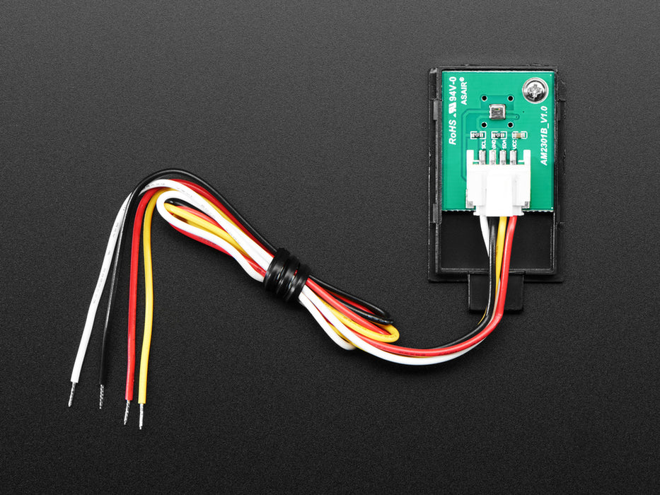 Top view of black humidity sensor sensor wired to a breadboard with an FeatherWing OLED display. The OLED shows the data from the temperature-humidity sensor.