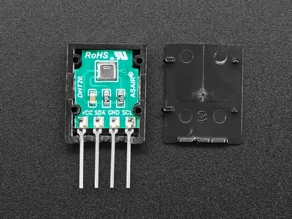 Top view of DHT20 sensor wired to a breadboard with an FeatherWing OLED display. The OLED shows the data from the temperature-humidity sensor.