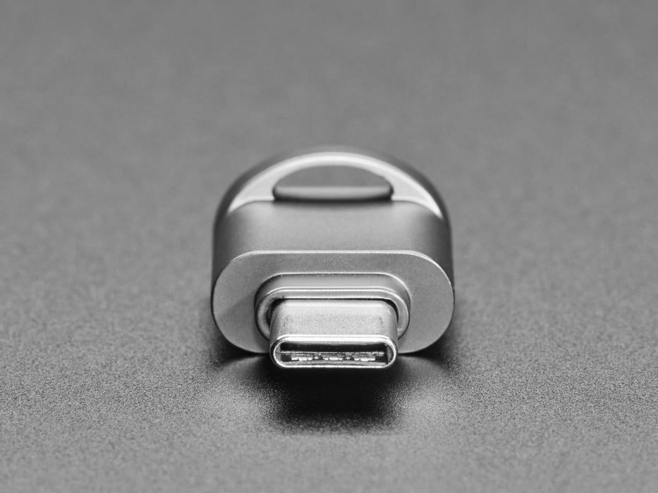 Angled shot of a microSD card reader with a key chain plugged into a laptop port.