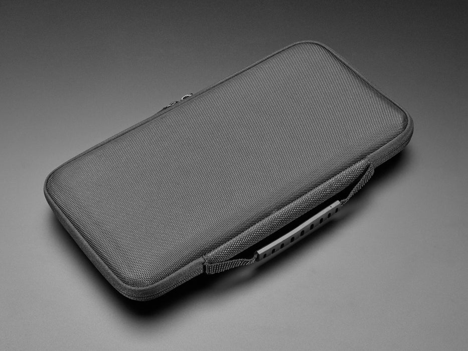 Angled shot of case sleeve opened up with an optical mouse and HDMI cable in the top pocket and a keyboard in the bottom half the case.