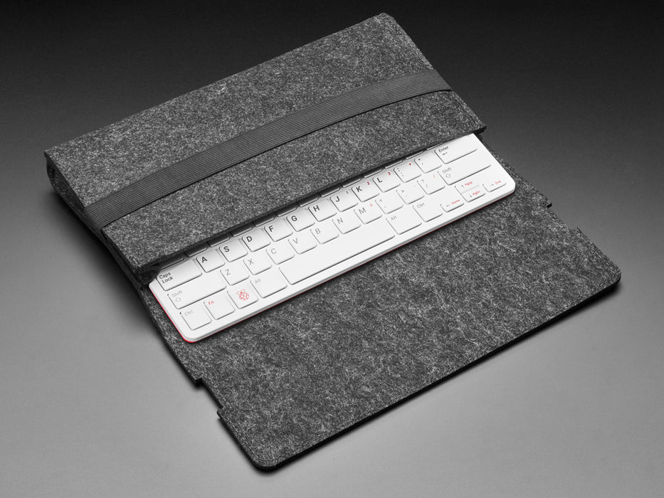 Top view of black fabric sleeve case opened up to reveal half of a red keyboard.