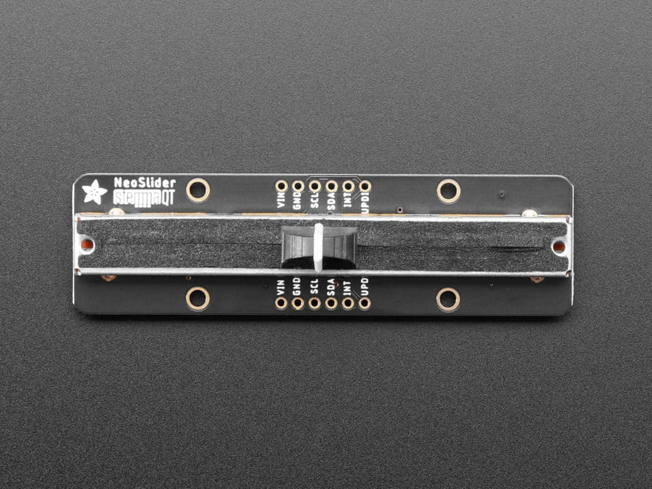 Long rectangular breakout board with a slide potentiometer changing colors as a hand moves up and down.