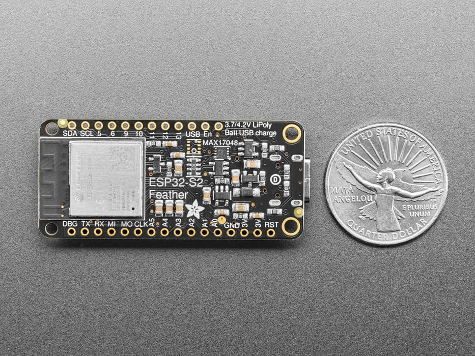 Adafruit ESP32-S2 TFT Feather powered on by a USB- C power source displaying the product tittle in a red, yellow, green, white and blue. 