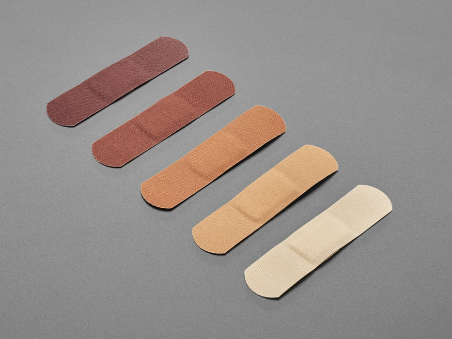 Five sets of bandages in four shades of brown out of their protective paper backing.