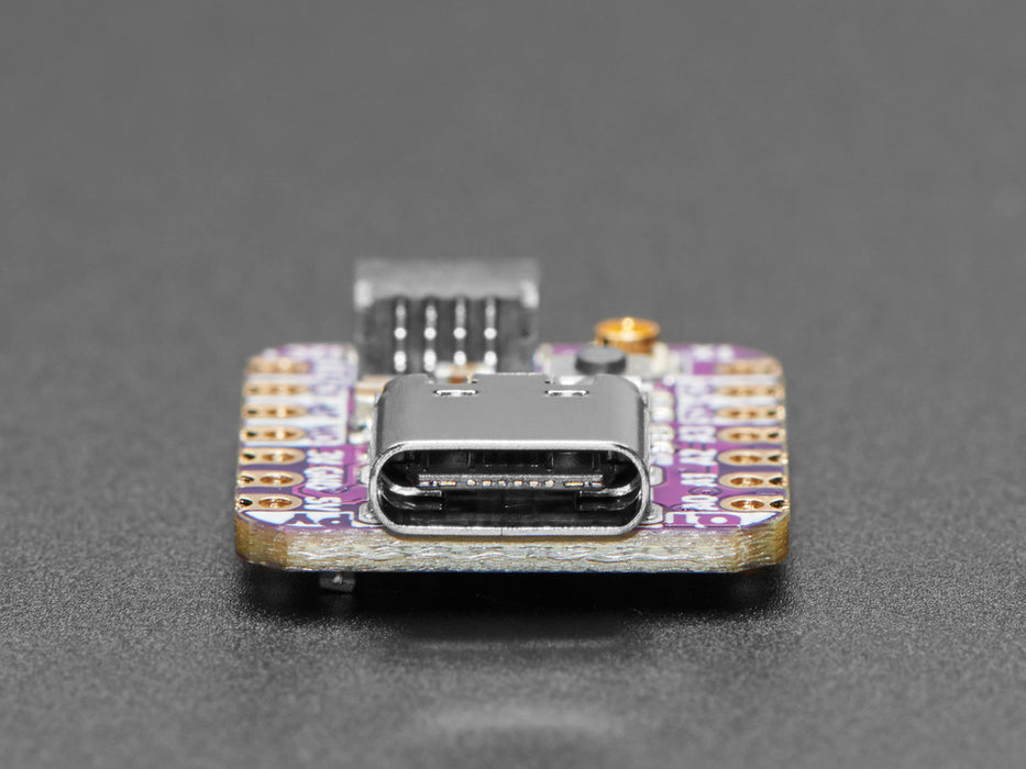 Angled shot of purple square-shaped microcontroller with a uFL antenna attached.