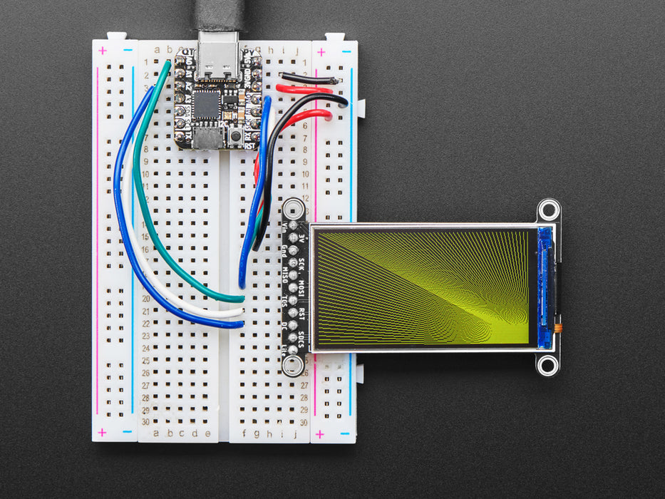 TFT display breakout soldered and assembled onto a half-size breadboard and wired up to a microcontroller. The color TFT screen displays a cycle of animations.