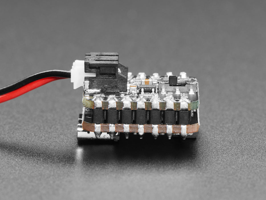 Video of a person with white painted nails unplugging a USB cable from a small, black, square-shaped lipo battery breakout board soldered to a similarly shaped microcontroller, which is also connected to a monochrome OLED display breakout. The OLED breakout displays battery and power data.