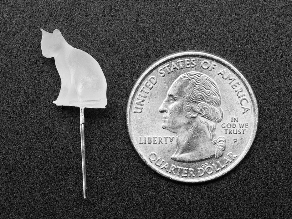 Close-up video of a cat-shaped LED. The LED glows a spectrum of white to green to purple light.