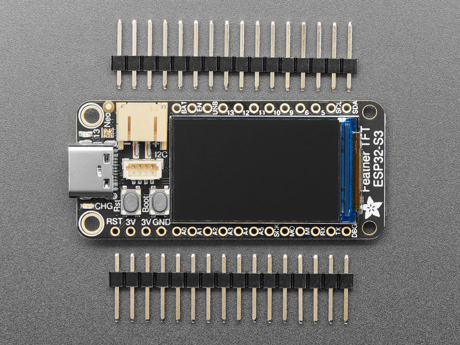 Top view of a purple rectangular microcontroller with a color TFT screen and powered by an ESP32-S3 chip. It is also connected to a Li-Poly battery and a lux sensor breakout. The TFT display reads in colored text: "Adafruit Feather
ESP32-S3 TFT Demo
Battery: 3.8V / 45%
I2C: 0xB, 0x10, "