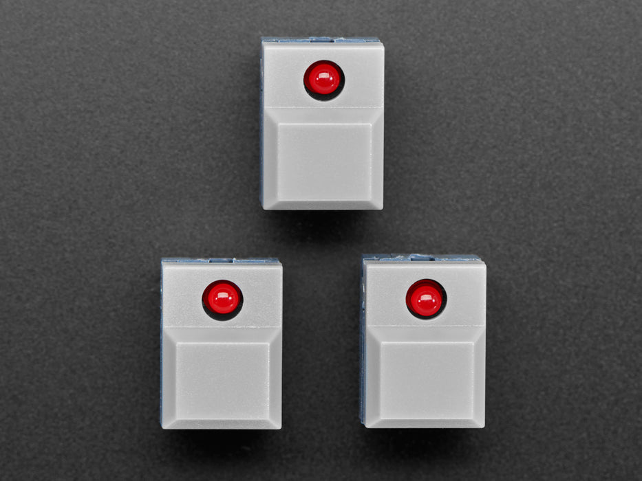 Angled shot of three gray plastic step switches with LED.