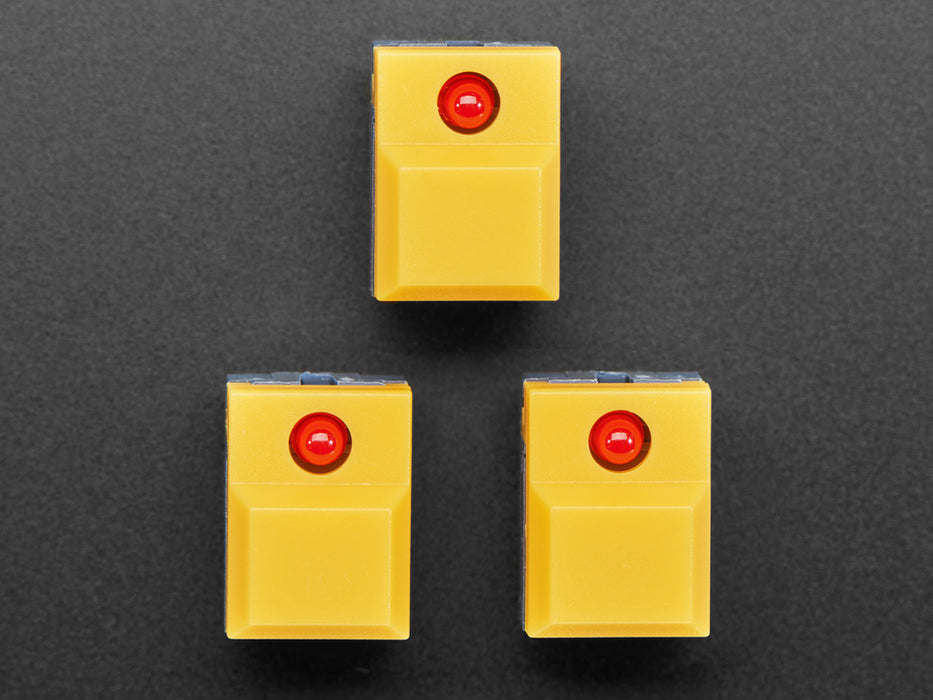 Angled shot of three yellow step-switches with LEDs.