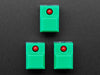 Angled shot of three green plastic step-switches with red LEDs.