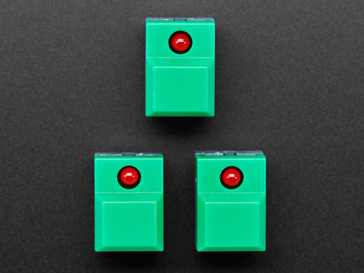 Angled shot of three green plastic step-switches with red LEDs.