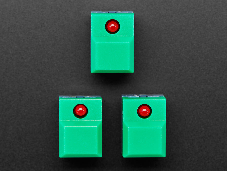 Angled shot of three green plastic step-switches with red LEDs.