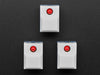 Angled shot of three white plastic step-switches with red LEDs.