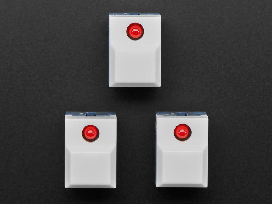 Angled shot of three white plastic step-switches with red LEDs.