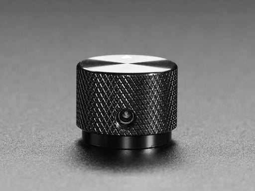 Angled shot of a black aluminum knob. A white triangle on top of the knob points at 5:00. 