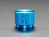 Angled shot of a blue aluminum knob. A white triangle on top of the knob points at 7:00. 