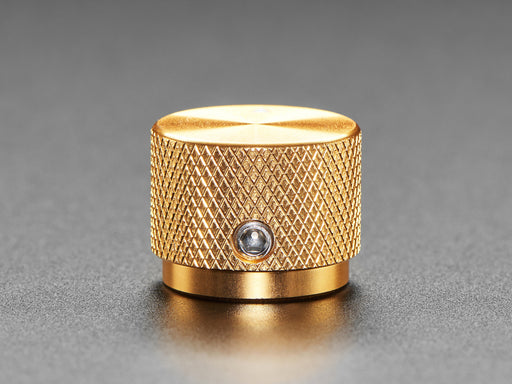 Angled shot of a gold aluminum knob. A white triangle on top of the knob points at 7:00.