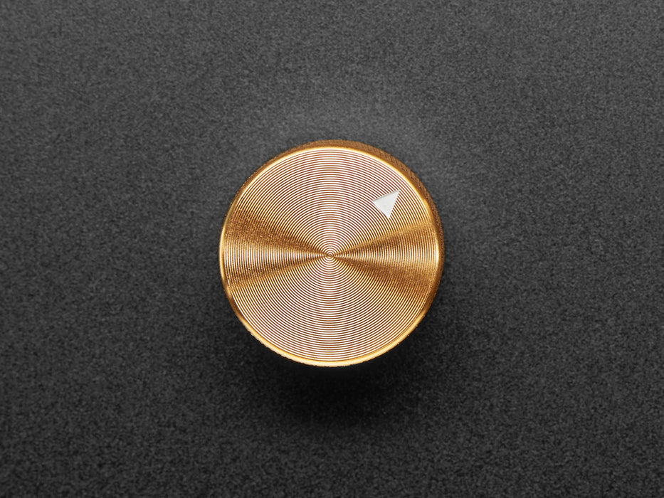 Angled shot of a gold aluminum knob. A white triangle on top of the knob points at 7:00.