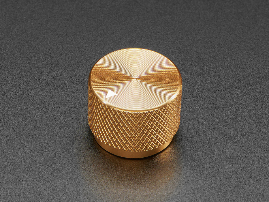 Angled shot of a gold aluminum knob. A white triangle on top of the knob points at 7:00.