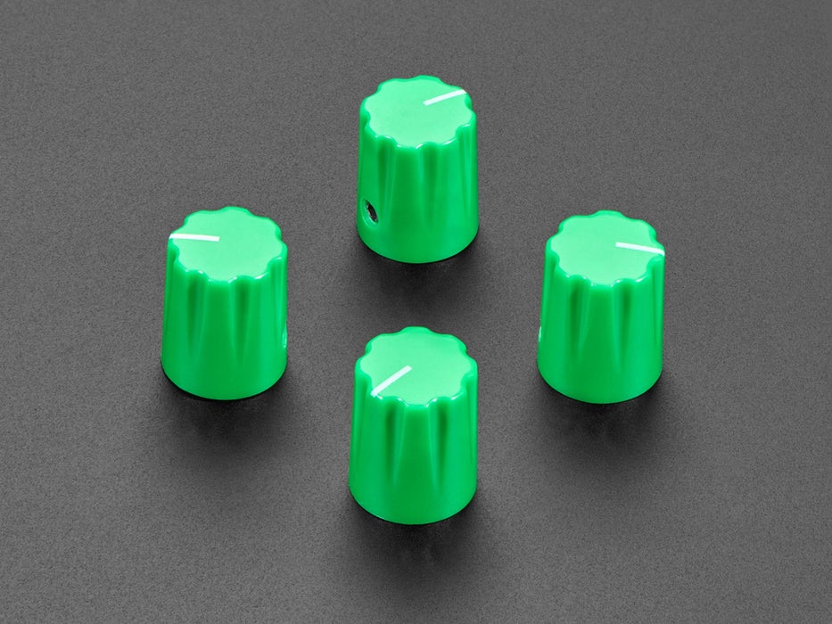 Angled shot of four green plastic micro knobs.