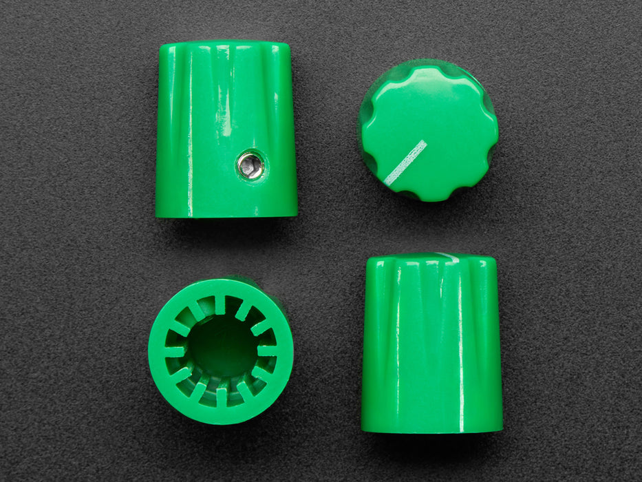 Angled shot of four green plastic micro knobs.