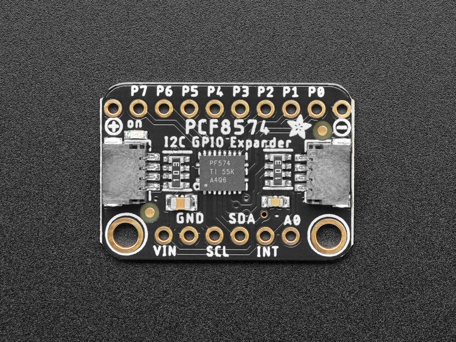 Adafruit PCF8574 I2C GPIO Expander Breakout connected to a QTPY displaying a hand clicking a button which lights up a red LED.