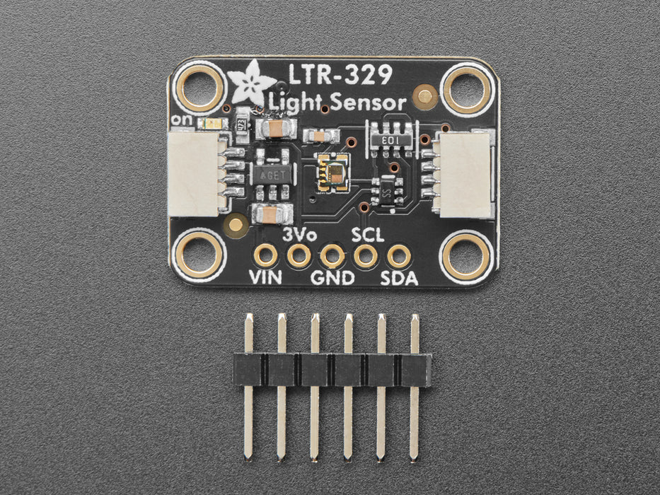 Overhead video of a white person's hand covering a light sensor breakout, which changes the visibility and infrared data on an OLED display breakout.