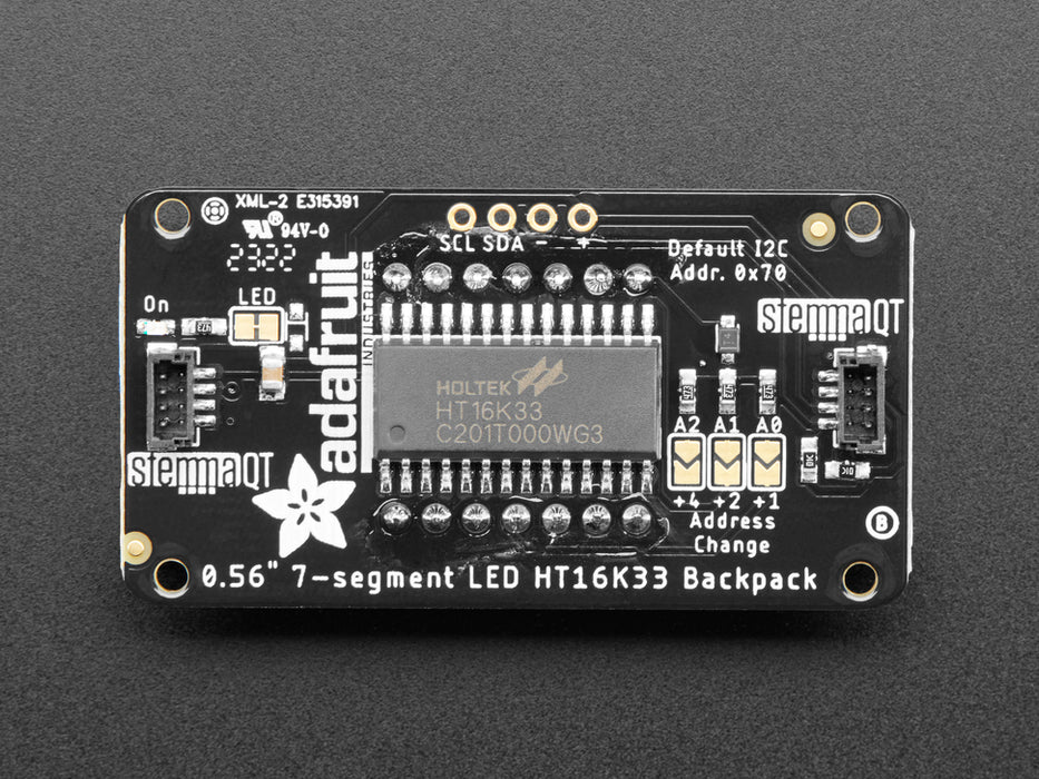 Red 7-segment clock display soldered to backpack with all segments lit