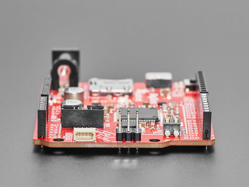 Angled shot of red credit-card sized microcontroller.