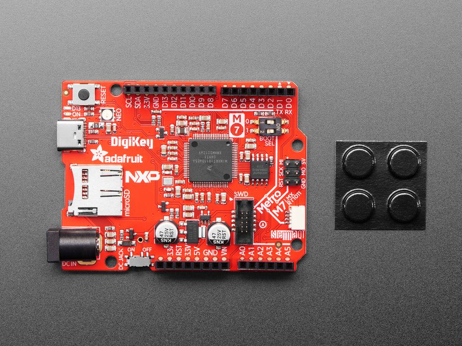 Angled shot of red credit-card sized microcontroller.